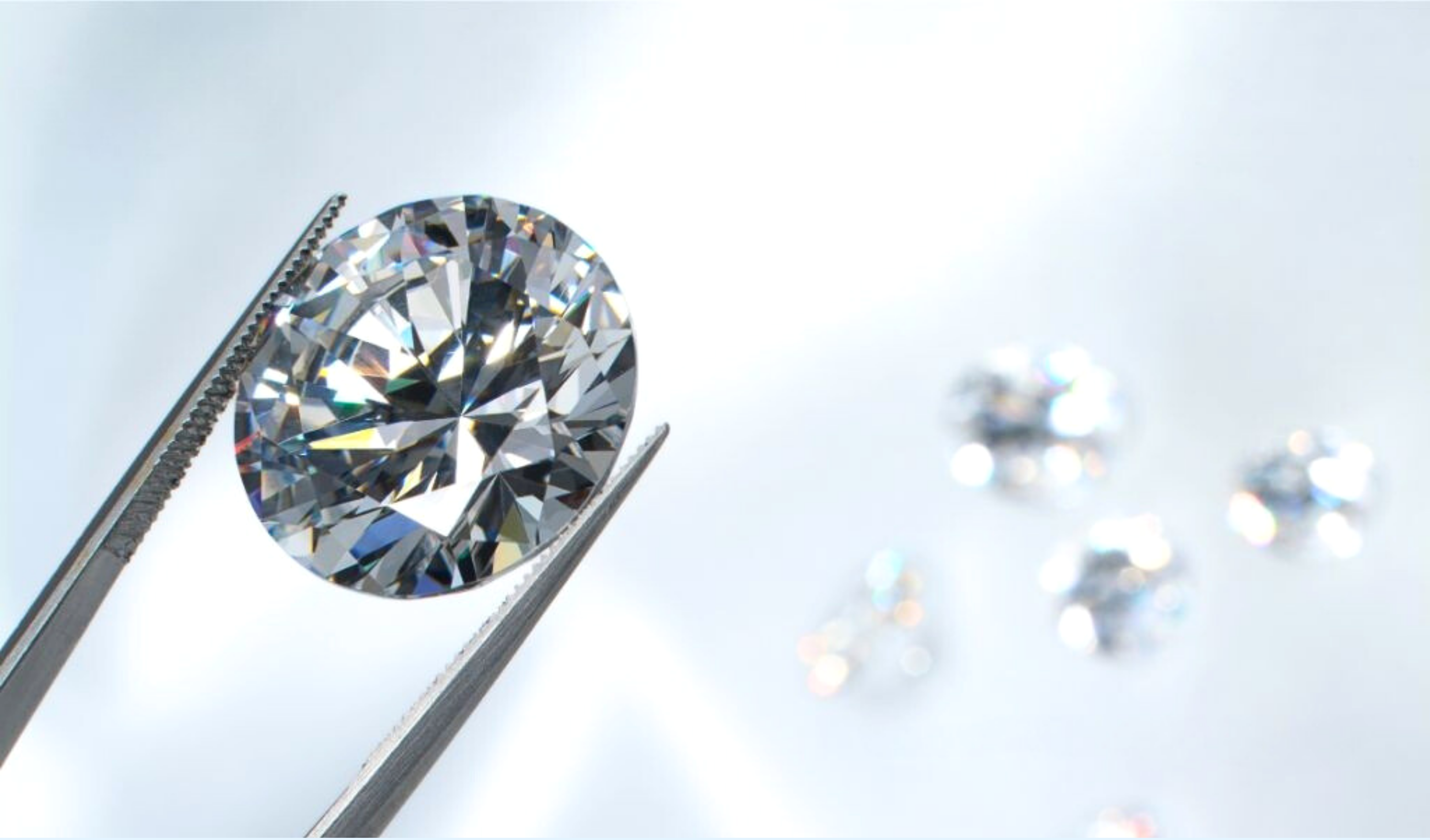 Close-up of sparkling lab-grown diamond stones, one held in tweezers for inspection
